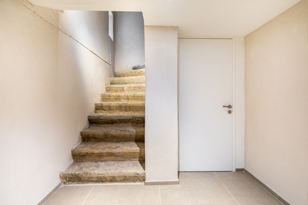 Photo of a medium sized modern curved staircase in Lyon with limestone treads.
