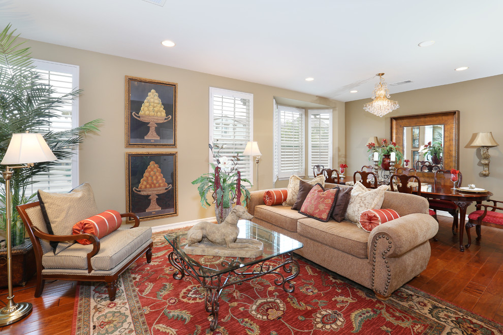This is an example of a tropical living room in Orange County with beige walls and medium hardwood floors.