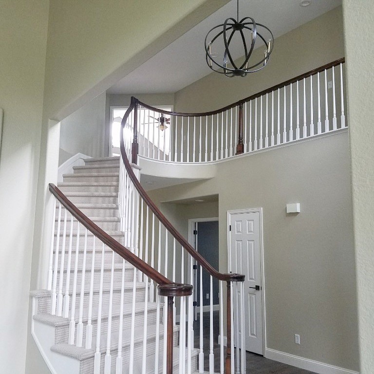 This is an example of a mid-sized traditional carpeted curved staircase in Denver with carpet risers and wood railing.