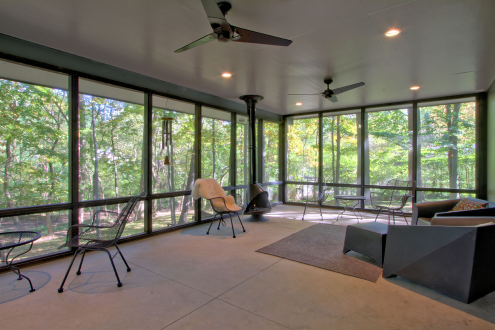 Large midcentury backyard screened-in verandah in Indianapolis with a roof extension.