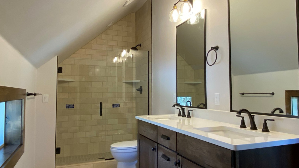 Inspiration for a rustic gray tile and limestone tile limestone floor, gray floor and double-sink bathroom remodel with shaker cabinets, brown cabinets, a one-piece toilet, gray walls, an undermount sink, quartzite countertops, a hinged shower door, white countertops, a niche and a built-in vanity