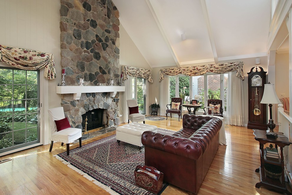 This is an example of a traditional living room in Toronto with beige walls, medium hardwood floors, a standard fireplace and a stone fireplace surround.