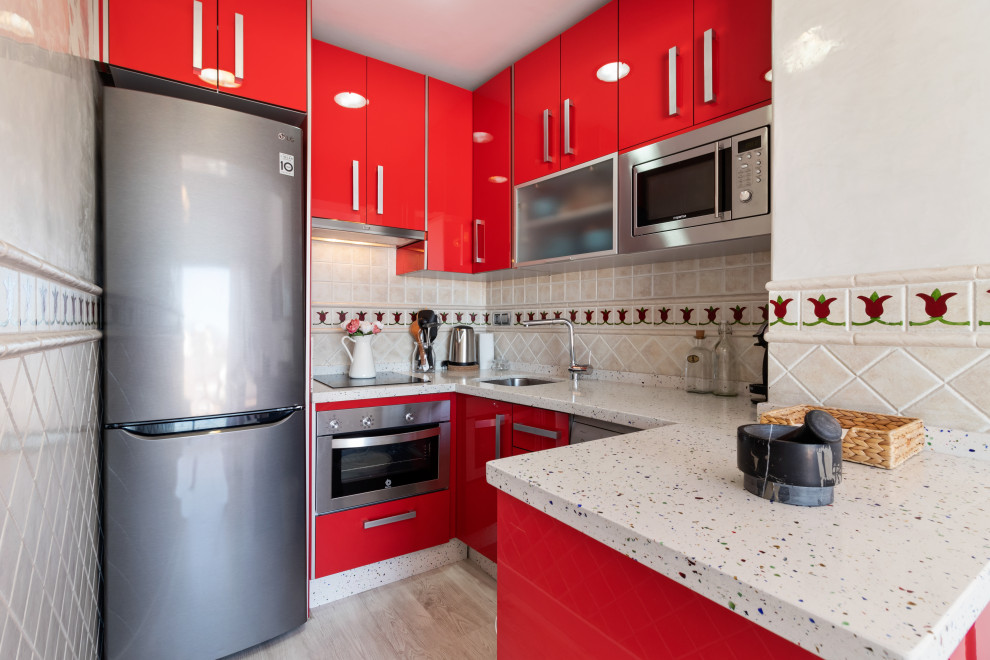 Design ideas for a small contemporary u-shaped kitchen in Malaga with a single-bowl sink, flat-panel cabinets, red cabinets, ceramic splashback, beige floor, grey benchtop, granite benchtops, beige splashback, stainless steel appliances, porcelain floors and a peninsula.