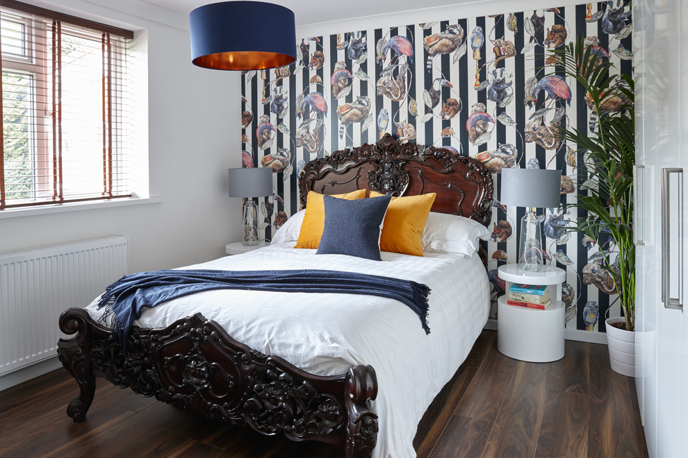 Eclectic bedroom in London with multi-coloured walls and medium hardwood floors.