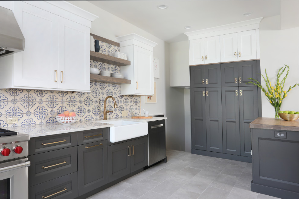 Mid-sized transitional u-shaped eat-in kitchen in Chicago with a farmhouse sink, recessed-panel cabinets, grey cabinets, quartzite benchtops, multi-coloured splashback, ceramic splashback, stainless steel appliances, porcelain floors, a peninsula, grey floor and white benchtop.