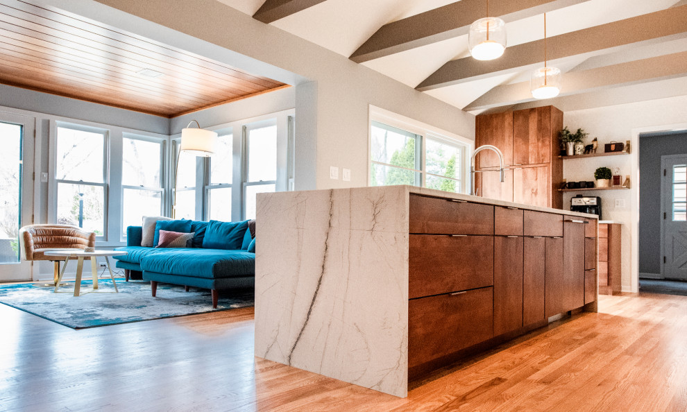 This is an example of a large midcentury galley open plan kitchen in Chicago with an undermount sink, flat-panel cabinets, medium wood cabinets, quartzite benchtops, white splashback, mosaic tile splashback, panelled appliances, medium hardwood floors, with island, brown floor and white benchtop.