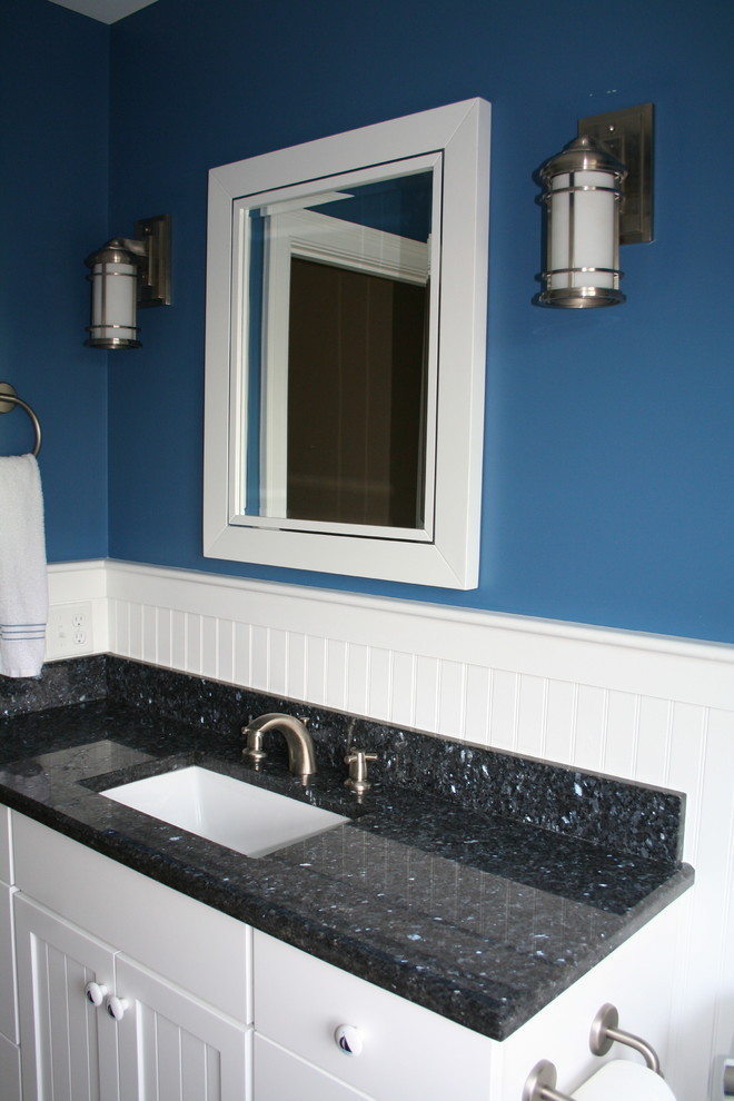 Photo of a small traditional bathroom in Providence with white cabinets, granite benchtops, a two-piece toilet, a drop-in sink, blue walls, porcelain floors and recessed-panel cabinets.
