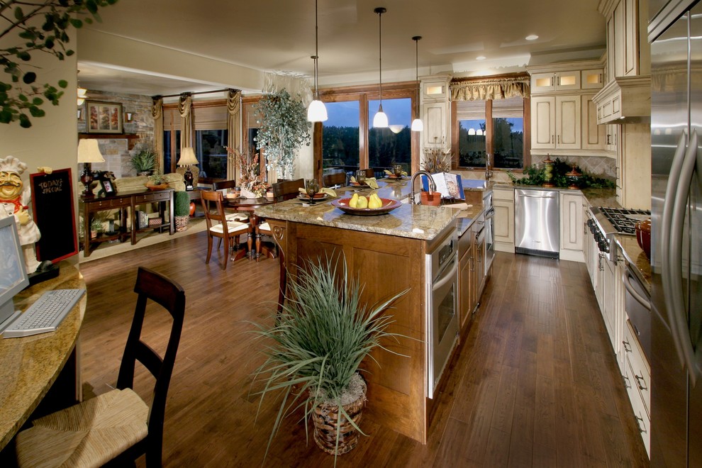 Example of a large mountain style u-shaped dark wood floor eat-in kitchen design in Denver with a farmhouse sink, raised-panel cabinets, light wood cabinets, granite countertops, beige backsplash, ceramic backsplash, stainless steel appliances, beige walls and an island