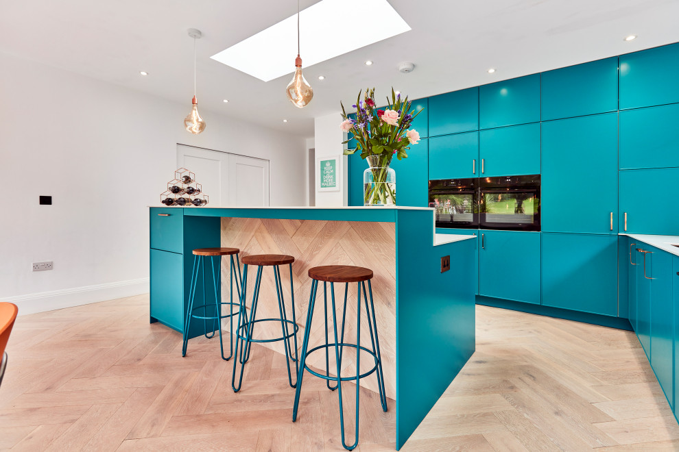 Mid-sized contemporary l-shaped eat-in kitchen in Other with a drop-in sink, recessed-panel cabinets, blue cabinets, quartzite benchtops, white splashback, black appliances, laminate floors, with island, beige floor, white benchtop and vaulted.