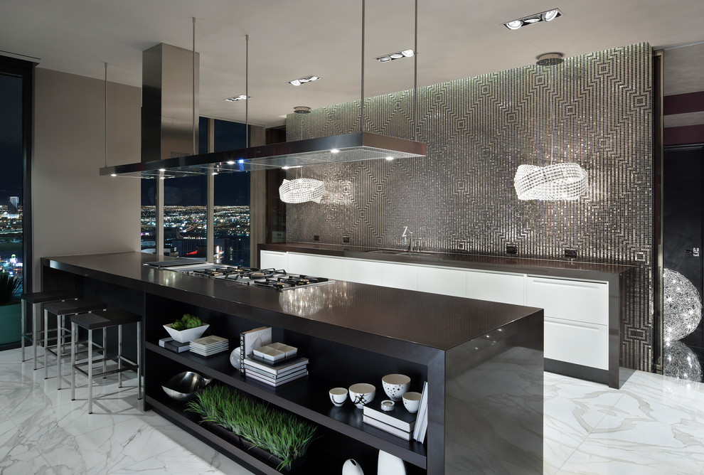 Inspiration for a large contemporary galley open plan kitchen in Las Vegas with a double-bowl sink, flat-panel cabinets, white cabinets, metallic splashback, mosaic tile splashback, marble floors, laminate benchtops, stainless steel appliances and a peninsula.