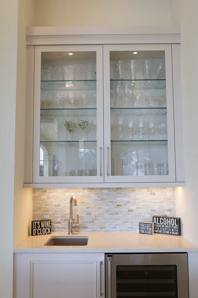 Enclosed kitchen - large transitional u-shaped porcelain tile and beige floor enclosed kitchen idea in Miami with an undermount sink, beaded inset cabinets, white cabinets, quartzite countertops, blue backsplash, subway tile backsplash, stainless steel appliances and an island