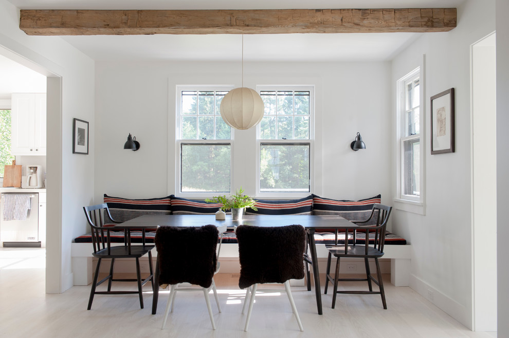 This is an example of a mid-sized scandinavian dining room in New York with white walls, light hardwood floors and no fireplace.