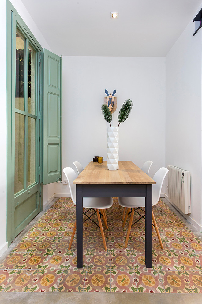 This is an example of a small eclectic dining room in Barcelona with white walls and multi-coloured floor.