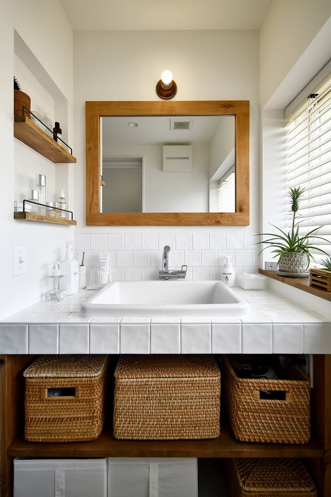 Design ideas for a transitional powder room with open cabinets, white walls, a drop-in sink and white benchtops.