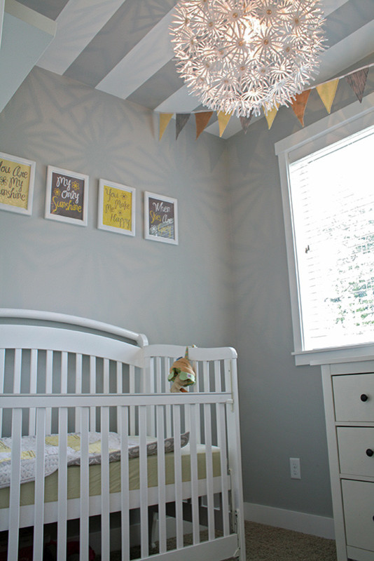 Exempel på ett litet amerikanskt könsneutralt babyrum, med grå väggar och heltäckningsmatta
