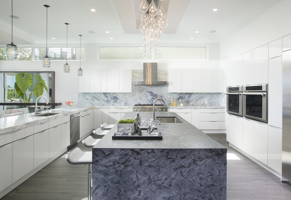 This is an example of a contemporary kitchen in Miami with an undermount sink, flat-panel cabinets, white cabinets, multi-coloured splashback, stainless steel appliances and with island.