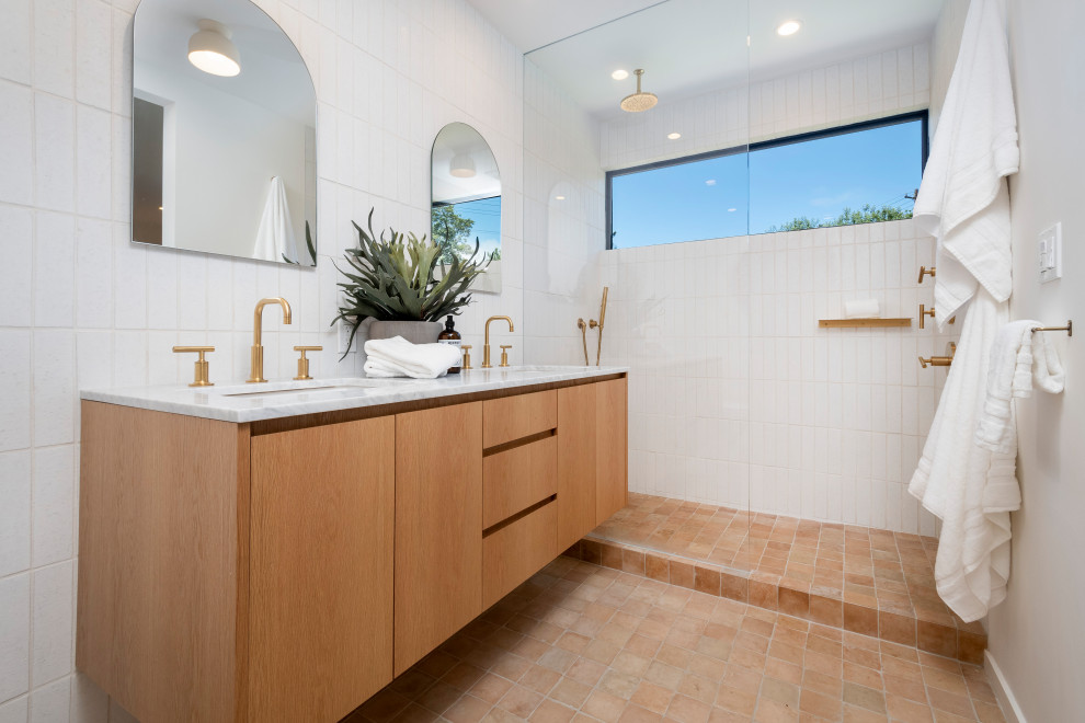 This is an example of a mid-sized contemporary master bathroom in San Francisco with flat-panel cabinets, light wood cabinets, white tile, porcelain tile, white walls, ceramic floors, an undermount sink, tile benchtops, orange floor, an open shower, white benchtops, a double vanity and a floating vanity.