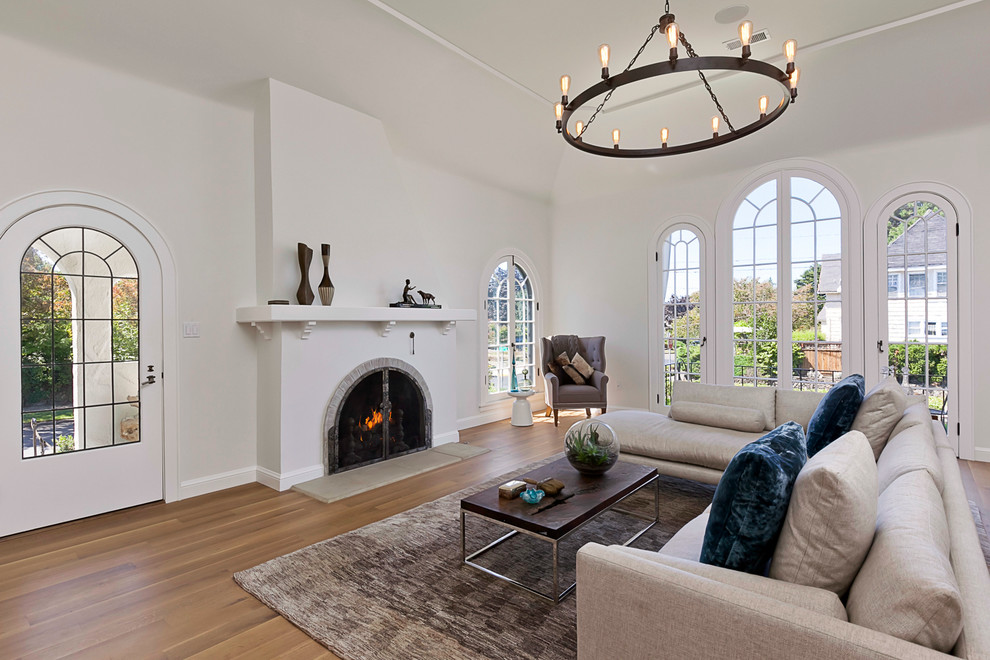 Transitional living room in Portland with white walls, medium hardwood floors and a standard fireplace.