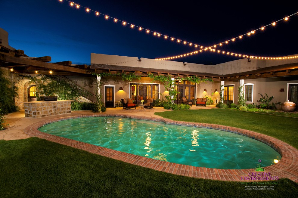 Hot tub - large backyard stamped concrete and custom-shaped hot tub idea in Phoenix