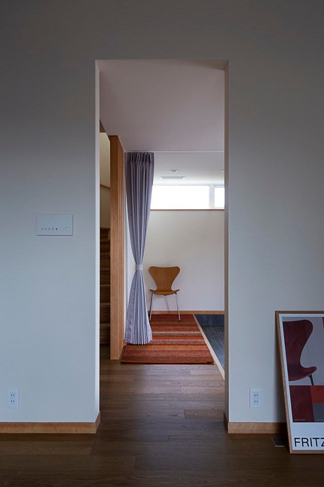 Immagine di un corridoio nordico di medie dimensioni con pavimento con piastrelle in ceramica, una porta singola, una porta in metallo, pavimento grigio, soffitto in carta da parati, carta da parati e armadio