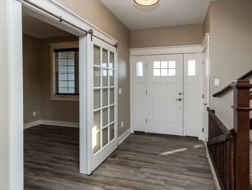 Example of a transitional vinyl floor front door design with beige walls and a white front door