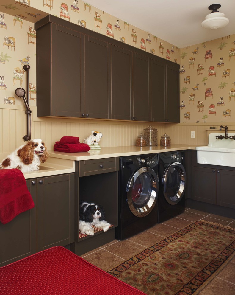 Photo of a traditional laundry room in Detroit with a farmhouse sink, shaker cabinets, dark wood cabinets, beige walls, a side-by-side washer and dryer and brown floor.