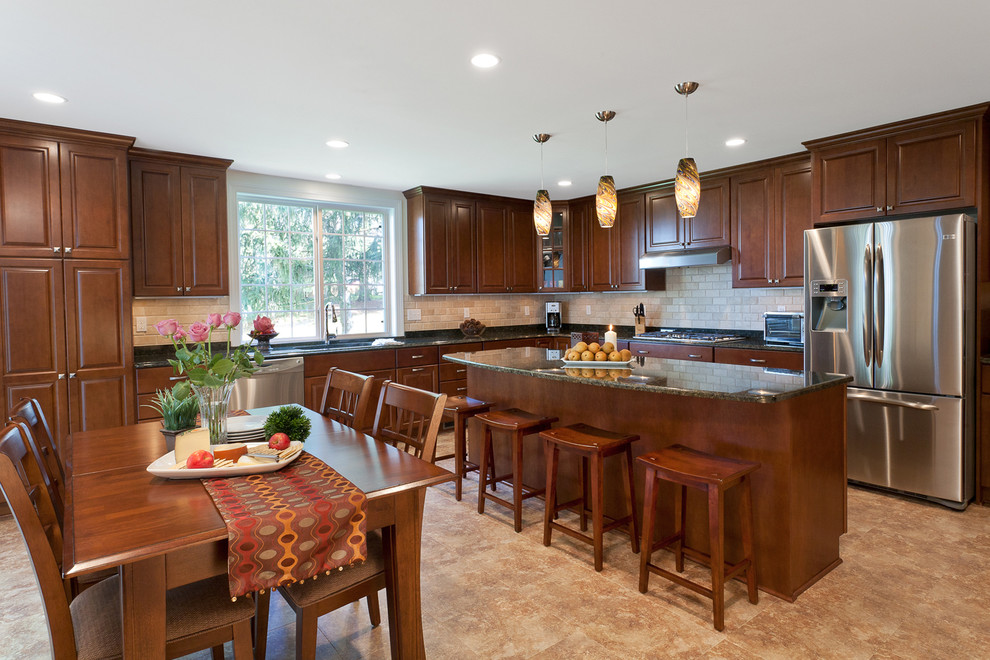 Large traditional u-shaped eat-in kitchen in DC Metro with an undermount sink, recessed-panel cabinets, dark wood cabinets, granite benchtops, ceramic splashback, stainless steel appliances, ceramic floors and with island.