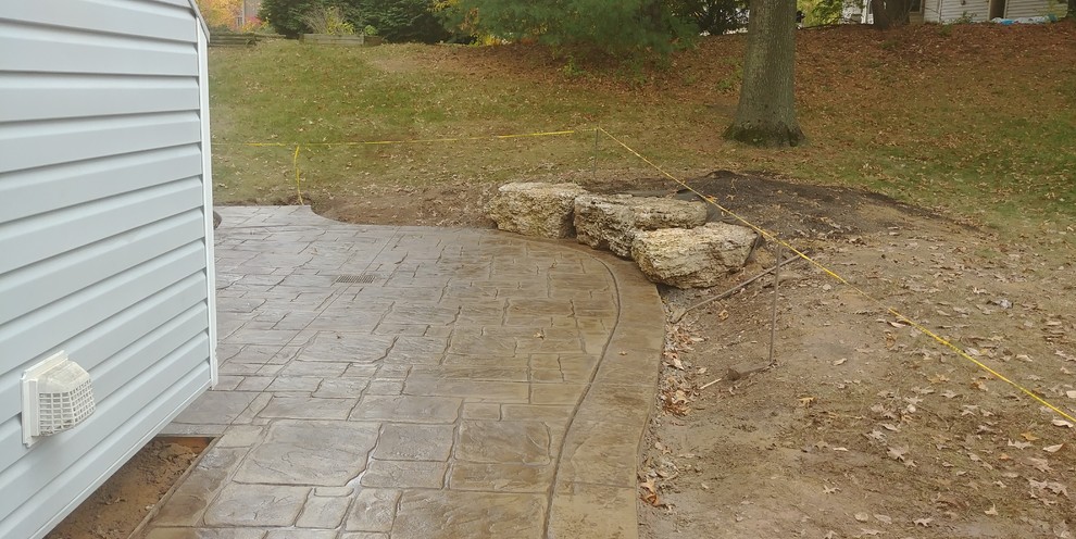 Stamped Concrete Patio with limestone boulder sitting wall in St Charles Missour