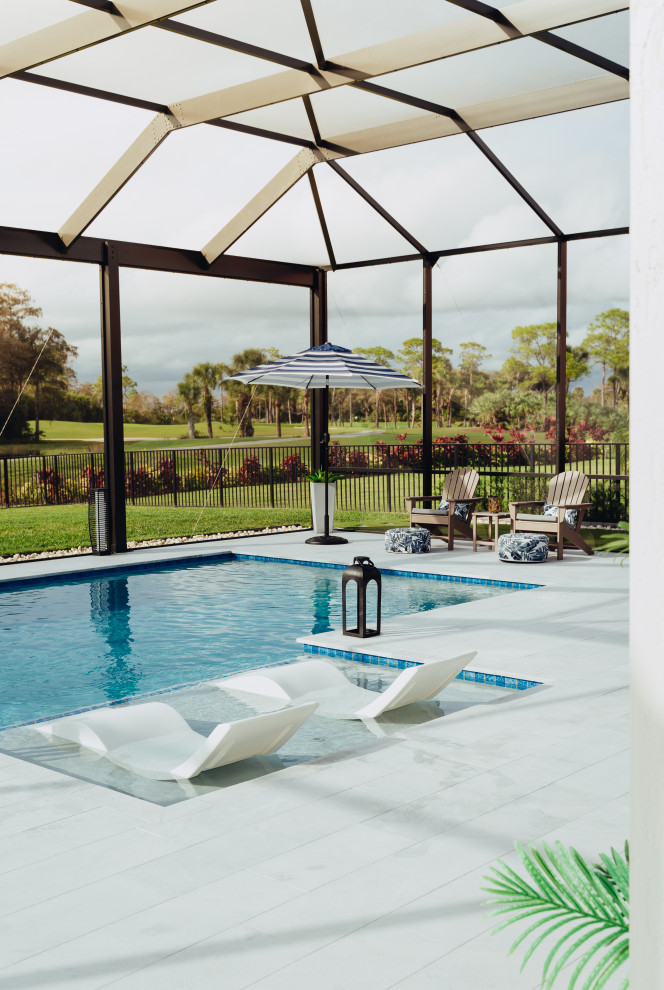 Imagen de piscina minimalista de tamaño medio rectangular en patio trasero con adoquines de piedra natural