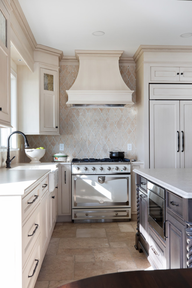 Inspiration for a mid-sized traditional l-shaped eat-in kitchen in Milwaukee with a farmhouse sink, beaded inset cabinets, distressed cabinets, quartz benchtops, beige splashback, limestone splashback, panelled appliances, limestone floors, with island, beige floor, white benchtop and exposed beam.
