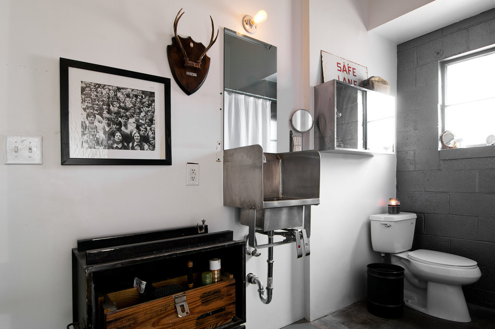 This is an example of an industrial bathroom in Salt Lake City with a wall-mount sink.