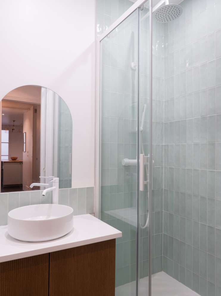 Cette image montre une salle de bain minimaliste de taille moyenne pour enfant avec des portes de placard marrons, une douche à l'italienne, un carrelage bleu, un mur blanc, un lavabo posé, une cabine de douche à porte coulissante, un plan de toilette blanc, une porte coulissante et meuble simple vasque.
