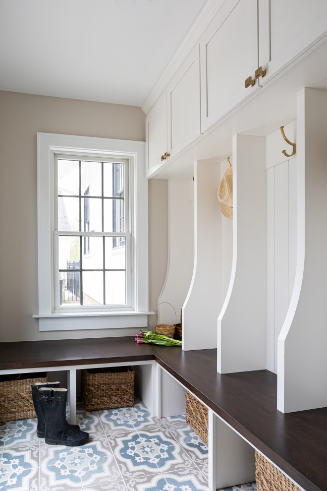 Mudroom - mid-sized transitional concrete floor mudroom idea in Columbus with beige walls