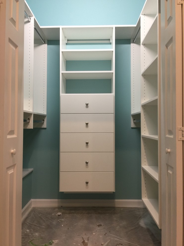 This is an example of a mid-sized traditional gender-neutral walk-in wardrobe in Charlotte with open cabinets, white cabinets and carpet.
