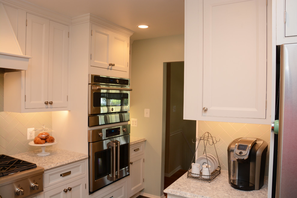 This is an example of a mid-sized traditional l-shaped separate kitchen in DC Metro with a farmhouse sink, recessed-panel cabinets, white cabinets, quartz benchtops, green splashback, porcelain splashback, stainless steel appliances, ceramic floors and no island.