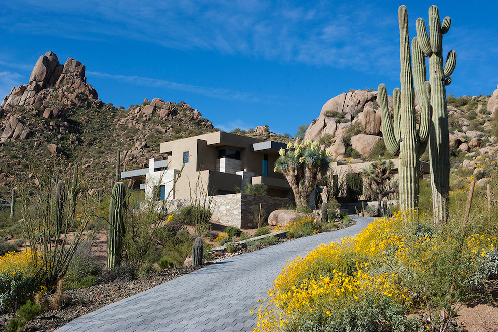 Inspiration for an expansive modern split-level grey exterior in Phoenix with stone veneer and a flat roof.