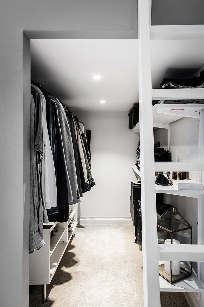 Mid-sized modern men's storage and wardrobe in Gothenburg with open cabinets.