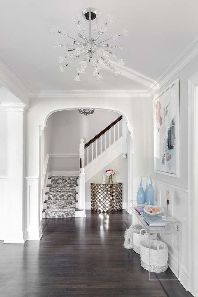 Photo of a small beach style foyer in New York with grey walls, dark hardwood floors and brown floor.