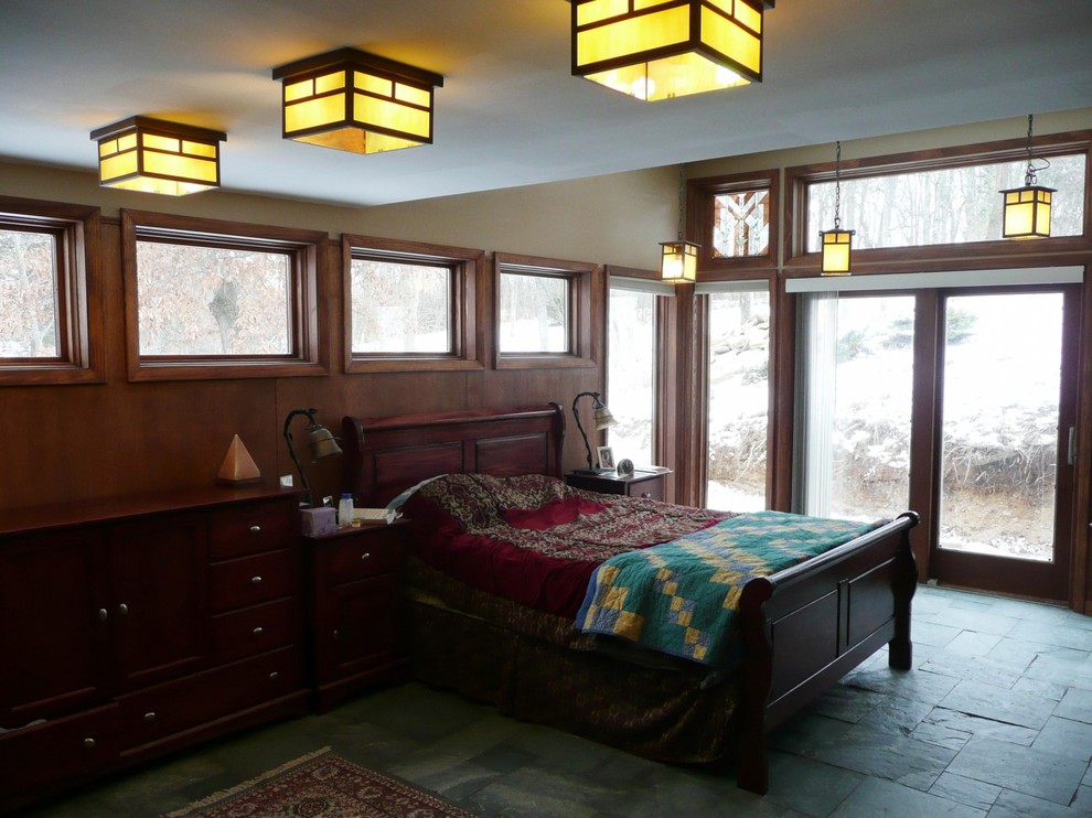 This is an example of a mid-sized arts and crafts master bedroom in Other with beige walls, slate floors and grey floor.