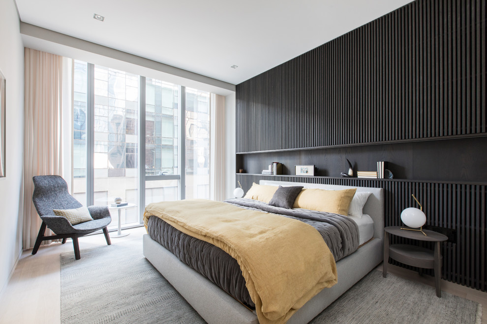 Inspiration for a mid-sized contemporary master bedroom in New York with light hardwood floors, black walls and beige floor.
