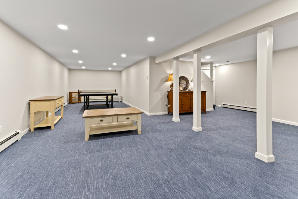 Beach style basement with carpet and blue floor.
