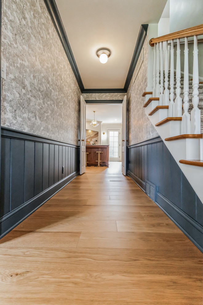 This is an example of a mid-sized transitional hallway in Cleveland with multi-coloured walls, medium hardwood floors, beige floor and vaulted.