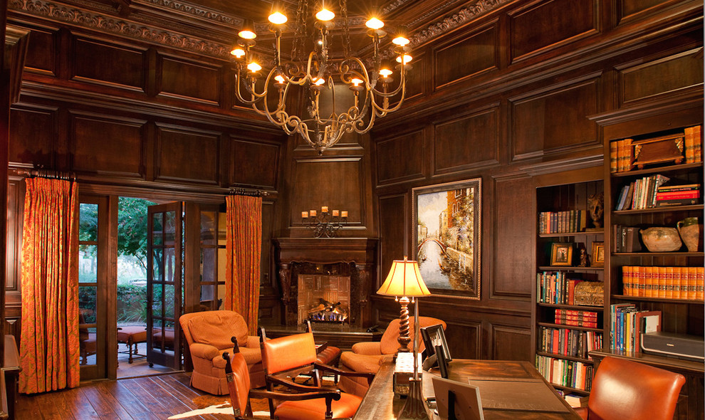 This is an example of an expansive traditional study room in Phoenix with brown walls, dark hardwood floors, a standard fireplace, a wood fireplace surround and a freestanding desk.