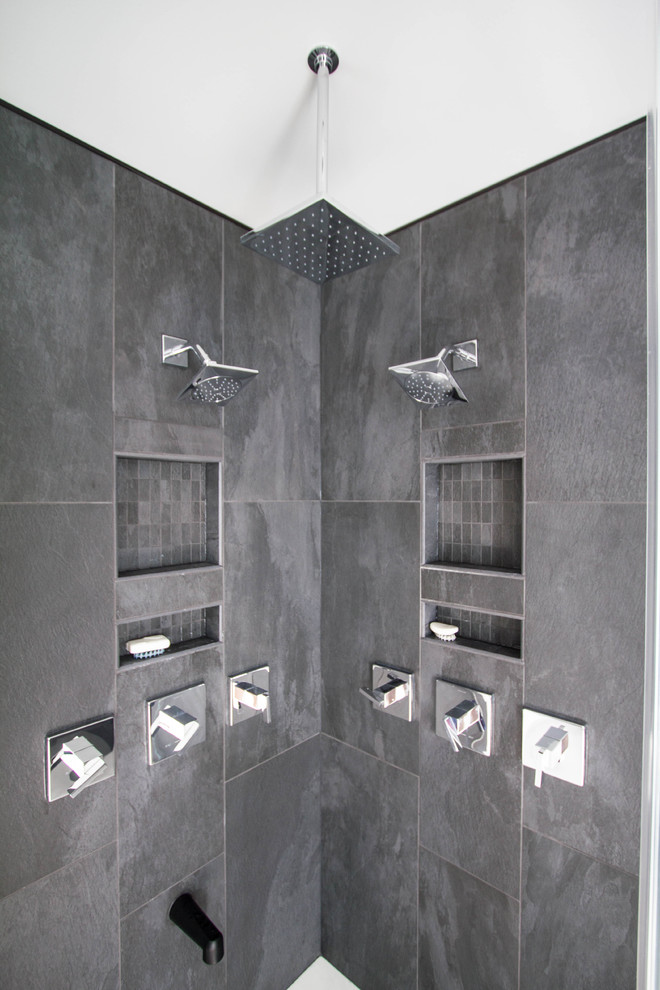 Mid-sized modern master bathroom in Philadelphia with flat-panel cabinets, black cabinets, a drop-in tub, a corner shower, black tile, porcelain tile, grey walls, porcelain floors, an integrated sink, solid surface benchtops, white floor and a hinged shower door.