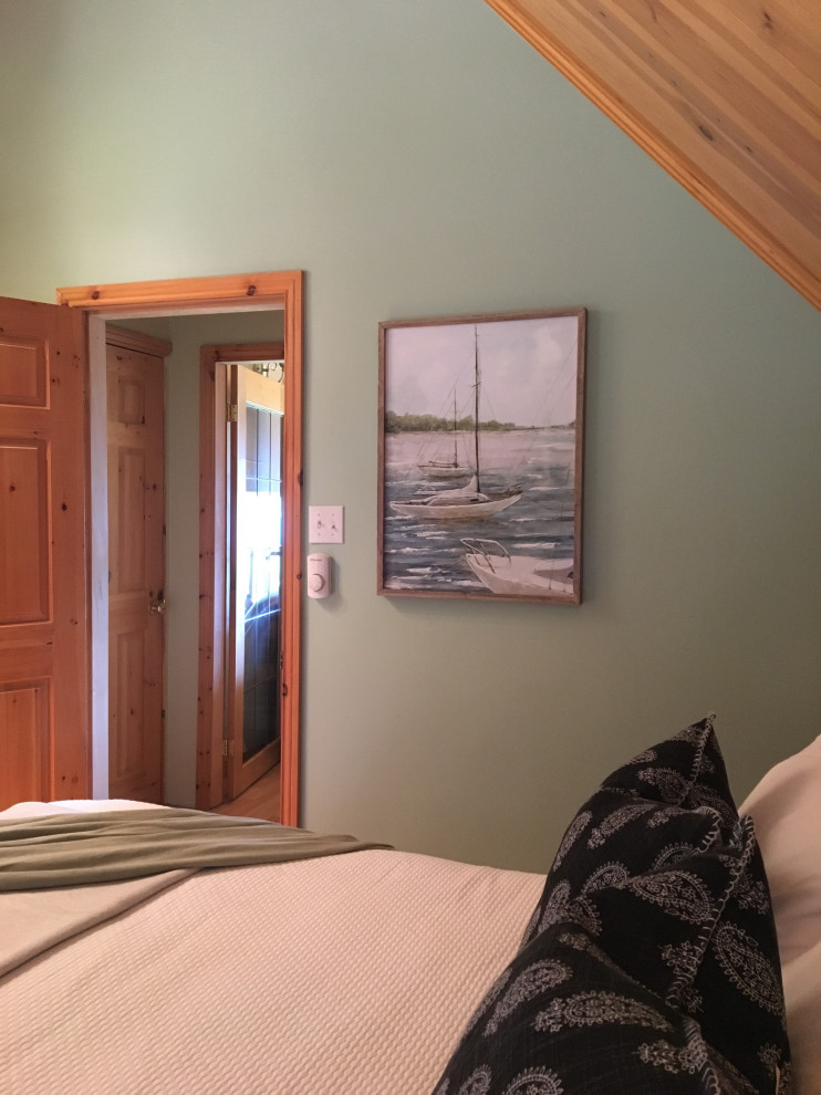This is an example of a small beach style guest bedroom in Other with green walls, laminate floors and orange floor.