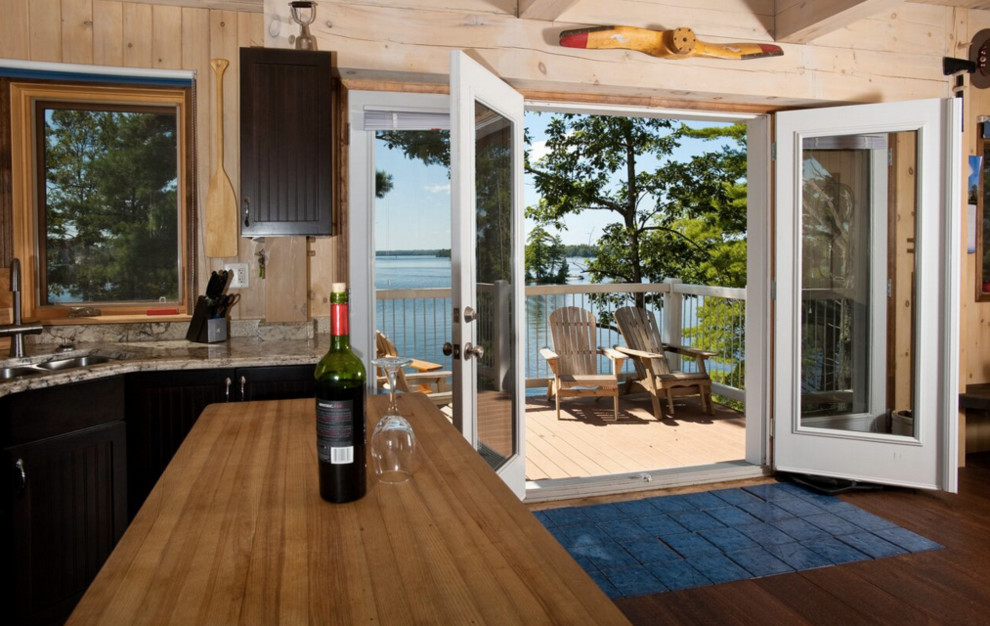 Inspiration for a large rustic galley light wood floor open concept kitchen remodel in Boston with an undermount sink, shaker cabinets, dark wood cabinets, granite countertops, stainless steel appliances and an island