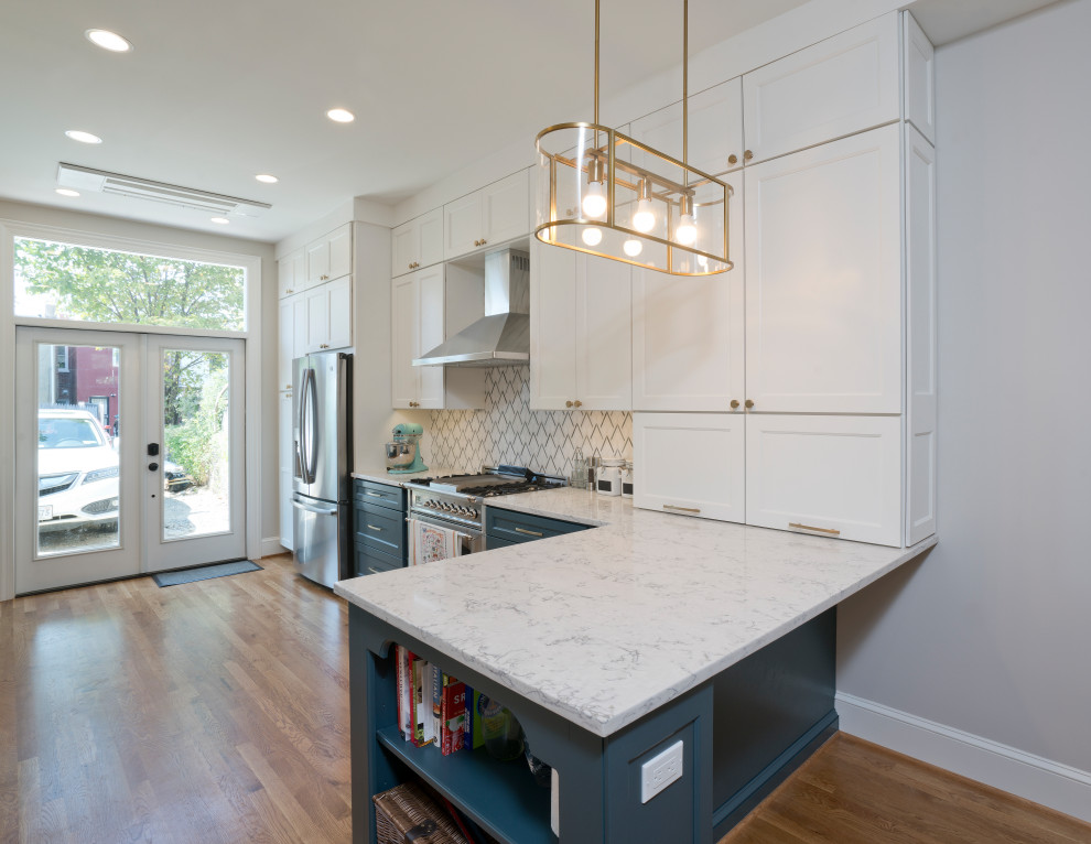 Inspiration for a small modern u-shaped eat-in kitchen in DC Metro with a farmhouse sink, recessed-panel cabinets, white cabinets, quartz benchtops, white splashback, ceramic splashback, stainless steel appliances, medium hardwood floors, a peninsula and blue benchtop.