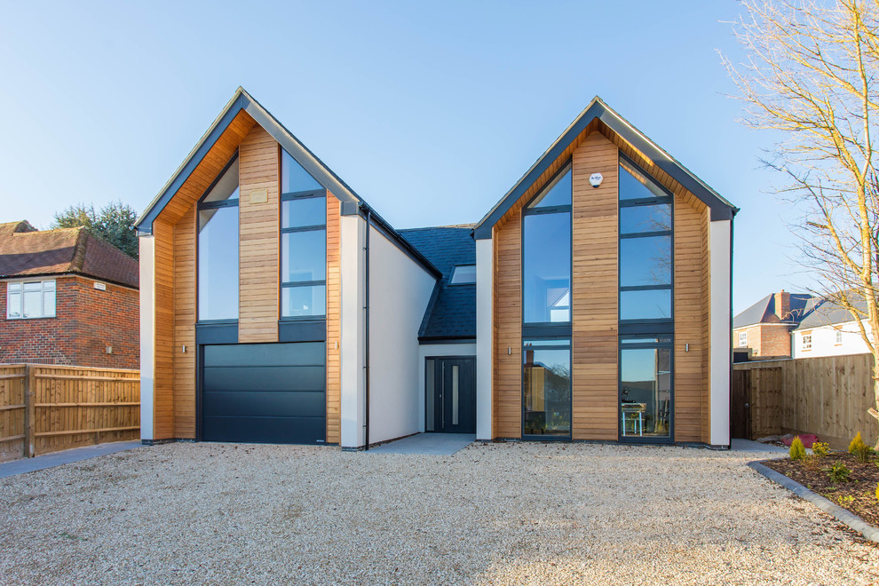 Photo of a large contemporary two-storey house exterior in Buckinghamshire with wood siding and a gable roof.
