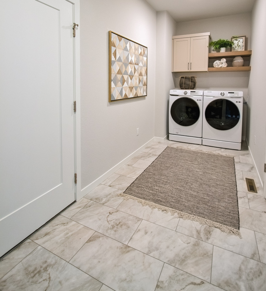 Immagine di una lavanderia multiuso contemporanea con ante con riquadro incassato, ante beige, pareti bianche, pavimento in vinile e lavatrice e asciugatrice affiancate