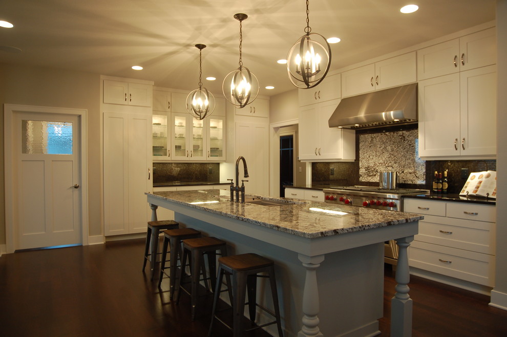 Example of a mid-sized transitional l-shaped dark wood floor open concept kitchen design with an undermount sink, shaker cabinets, white cabinets, granite countertops, brown backsplash, stone slab backsplash, stainless steel appliances, gray walls and an island